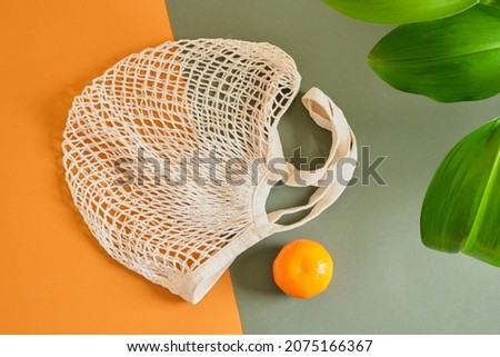 whisker bag and tangerine on brown green background, leaves for making fabrics, zero waste lifestyle concept, fabrics from fruits and waste