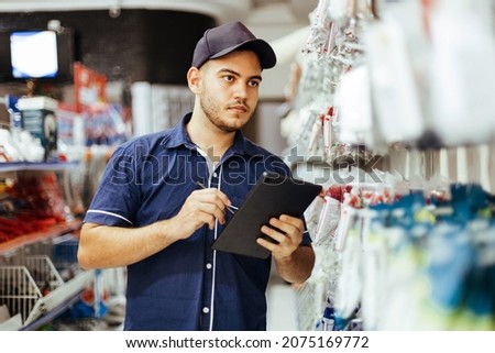 Young latin man working in hardware store Royalty-Free Stock Photo #2075169772
