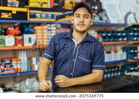 Young latin man working in hardware store Royalty-Free Stock Photo #2075169775