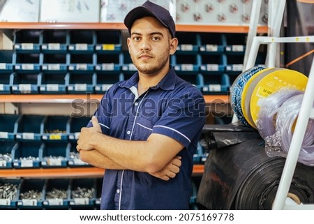 Young latin man working in hardware store Royalty-Free Stock Photo #2075169778
