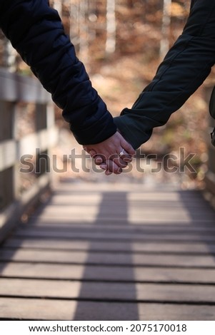 a newly engaged couple holding hands Royalty-Free Stock Photo #2075170018
