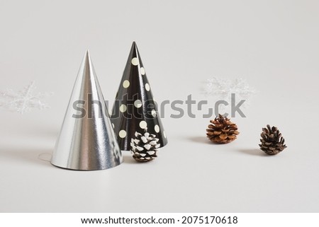paper homemade party hat and christmas decor on a gray background, postcard copy space for the new year, eco friendly holiday concept