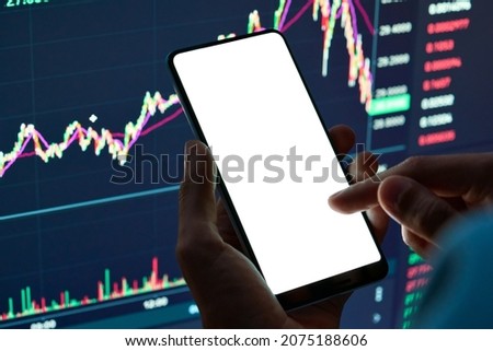Male cryptocurrency trader investor analyst hand holding cell phone with white mockup screen doing stock market data price analysis pointing finger using trading mobile app, stock application ads.