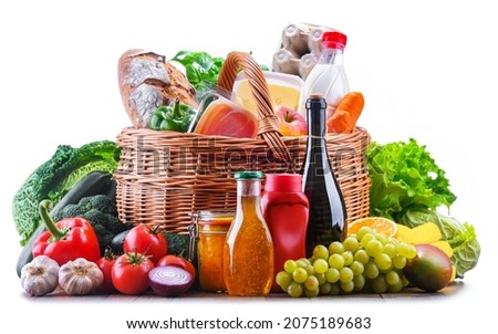 Wicker basket with assorted grocery products including fresh vegetables and fruits Royalty-Free Stock Photo #2075189683