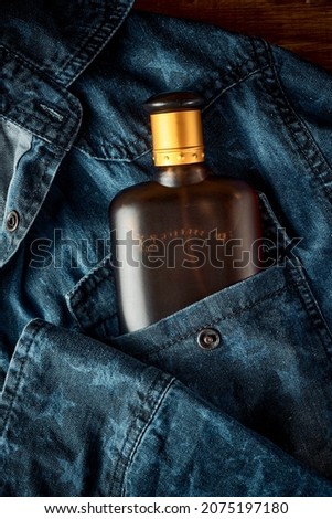 A bottle of parfume for men on denim jeans background, male style, scent of a man Royalty-Free Stock Photo #2075197180