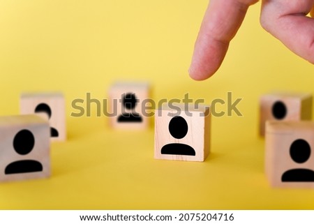 The search for new managers to lead organizations and teams is shown using wooden cubes, on a yellow background. This is a picture showing the search for a new head of the organization.