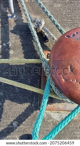 Rope hawsers and rusting bollard at Wexford harbour Royalty-Free Stock Photo #2075206459