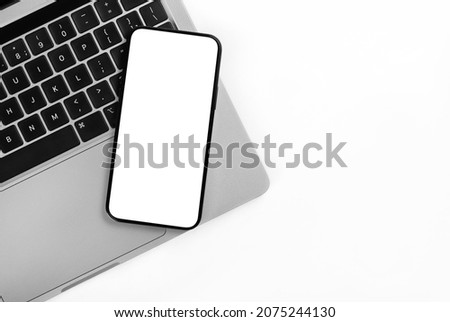 New iPhone on a laptop background. Royalty-Free Stock Photo #2075244130