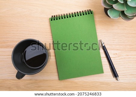 open notepad, cup of coffee, pen ,moose on wooden background spiral notebook on table Business, planning, education, morning life working from home concept Top view Flat lay Mock up
