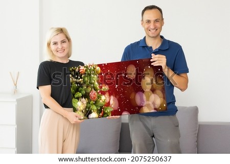 family holding photo canvas with christmas picture