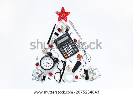 christmas tree made of stationery, calculator, glasses, alarm clock, magnifier, red balls, Concept of the holiday Christmas and New Year in the office, Creative design ideas