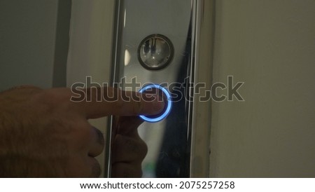 Mans hand pressing elevator down button. HDR. Close up of male finger getting the elevator by pushing the silver metal button.