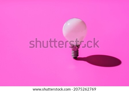 White minion light bulb on pink background,
Minimalist composition, the concept of a bright idea