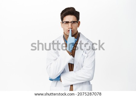 Angry doctor shushing, show taboo sign, press finger to lips and hush, shhh gesture, tell to be quiet, silence, standing over white background