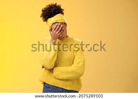Upset tired african-american female entrepreneur facepalm bow head close eyes palm pressed face embarrassed stupid inappropriate behaviour drunk coworker standing annoyed irritated yellow background Royalty-Free Stock Photo #2075289103