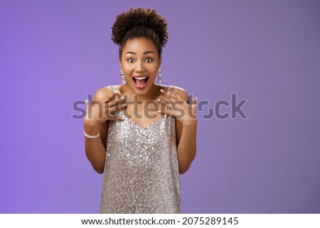 Amazed surprised attractive african-american young woman in glittering evening night dress scream happiness pointing herself amused cannot believe lucky win casino lottery, blue background Royalty-Free Stock Photo #2075289145