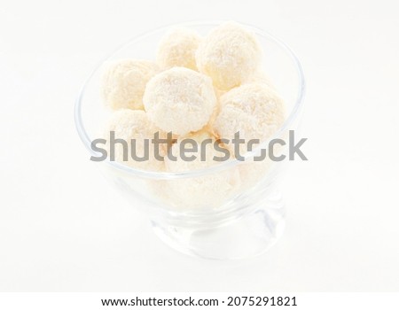 Coconut white balls of cakes in a glass on a white background