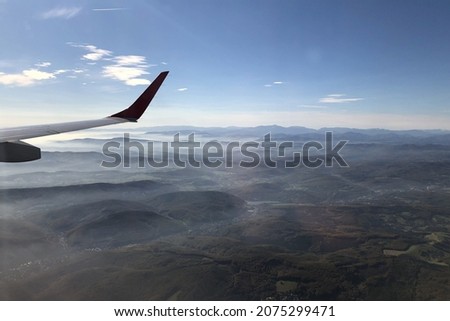landscape view out of an airplane with mountains and clouds