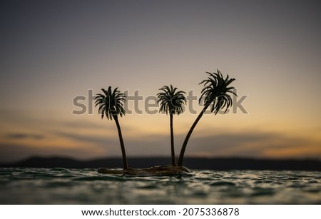 Romantic sunset scene. Fantasy landscape with little island with palms on sunset. Creative table decoration. Fantasy tropical beach. Selective focus.
