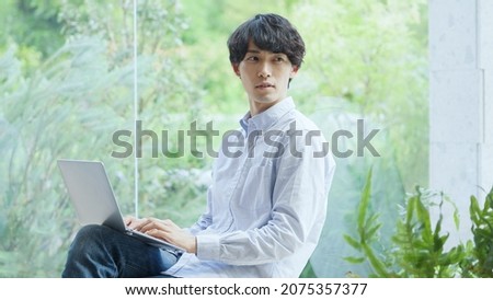 Asian young man working with a computer Royalty-Free Stock Photo #2075357377
