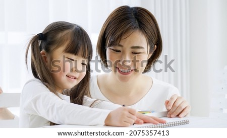 Girl drawing a picture with her mom