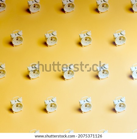 Minimal design pattern of clocks. Time concept banner. Pattern composition of white clocks on pastel yellow background. Minimalist isometric concept.Retro alarm clocks.Wasting time concept