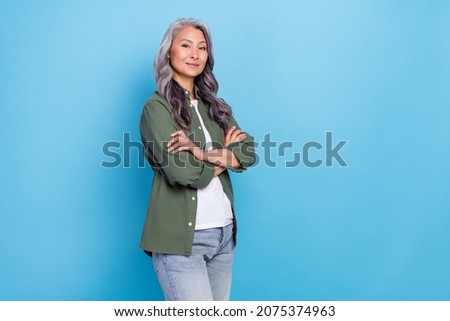 Photo of cool elder white hairdo lady crossed arms wear khaki shirt jeans isolated on blue color background