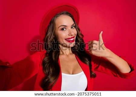 Photo of cool brunette lady do selfie show thumb up wear cap blazer isolated on red color background