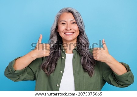 Photo of cool old grey hairdo lady show thumb up wear khaki shirt isolated on blue color background