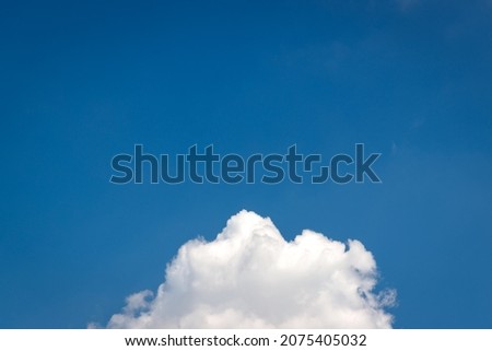 Beautiful shape of white fluffy cloud in clear blue sky. The cloud is located at the bottom of the picture. Nature Cloudscape background.