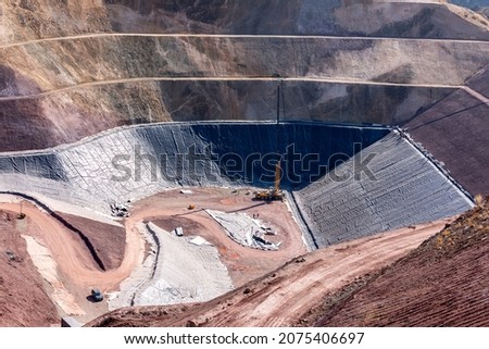 View of the industrial mine waste dam (tailing dam). A tailings dam is typically an earth-fill embankment dam used to store byproducts of mining operations after separating the ore from the gangue. Royalty-Free Stock Photo #2075406697