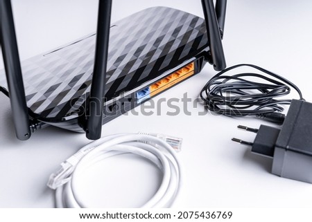 Wi-Fi router close-up, wireless Internet device close-up, selective focus, tinted image, wires needed to connect the router to the Internet Royalty-Free Stock Photo #2075436769