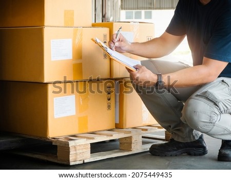 Warehouse Workers Holding Clipboard his Doing Inventory Management Packaging Boxes. Shipping Cargo Goods Boxes Checking Stock. Shipment Boxes. Warehousing Storage.	 Royalty-Free Stock Photo #2075449435