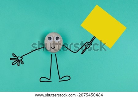 Animated pebble with a happy face holds big memo on blue paper background