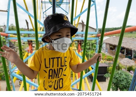 A boy rides a ferris wheel in an Indonesian amusement park.