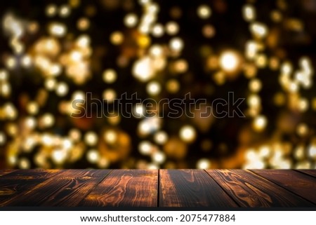 Table Christmas background. Lights of golden bokeh and wooden rustic texture surface for food, drinks and presents.