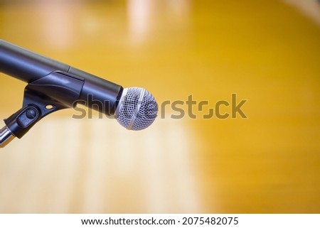 Close up of microphone on a podium in an auditorium with gold background