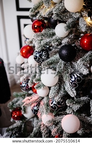 Decorated Christmas tree close-up. Red and white balls and garland lights with lanterns. Winter holiday christmas decorations