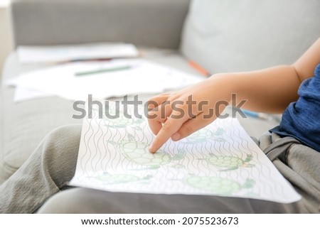 Cute little boy coloring pictures at home, closeup