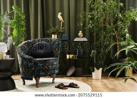 Creative composition of living room interior design with designed armchair, black geometric console, plants and golden accessoriers. Urban jungle concpet. Template.
