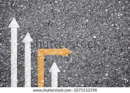 concept of different business and decisions. Yellow arrow crossing direction, white arrow on asphalt road. With copy space.