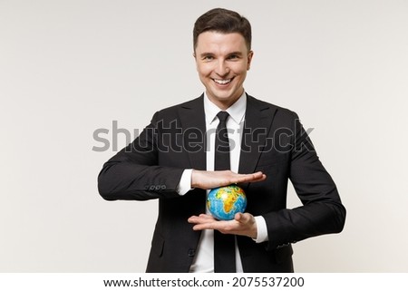 Young successful rich employee business corporate lawyer man in classic formal black grey suit shirt tie work in office holding in palms Earth world globe isolated on white background studio portrait