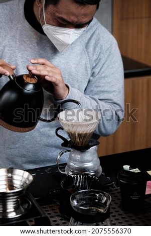 a barista is doing pour over manual brew coffee method with v60