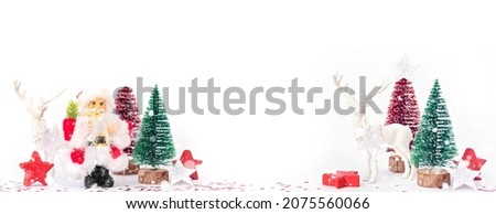 Santa, Christmas deer and festive decorations on table. Christmas still life web banner