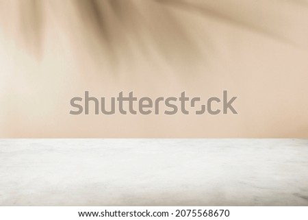 Tropical palm tree shadow on cream wall and luxury marble table for product placement. Natural layout design background. Abstract summer light cosmetic stand mockup. Royalty-Free Stock Photo #2075568670
