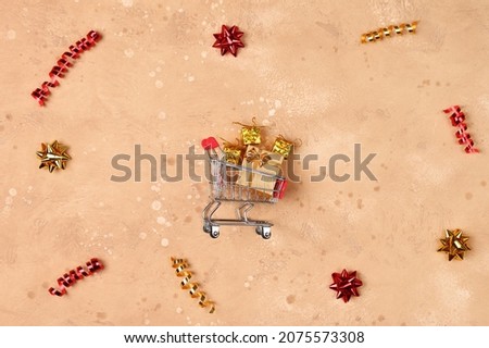 Beautiful background with shopping cart and gifts . Top view, flat lay. Christmas, new year concept. Copy space