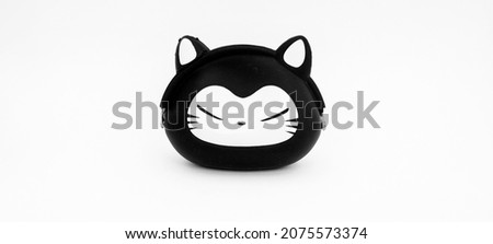 A cute cat head coin purse, made of rubber with a black and white color combination