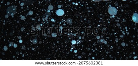 Blurred snowflakes on a dark background. Overlay image for snowfall effect.