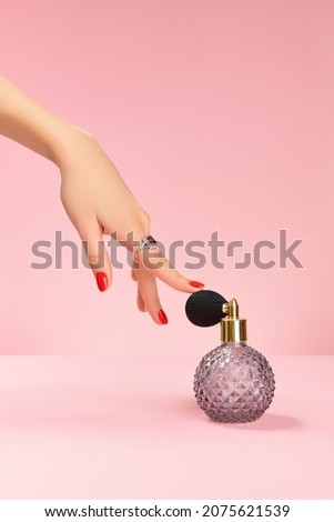 Well-groomed female hand with a ring touch perfume in retro bottle Trendy fashion accessories. Royalty-Free Stock Photo #2075621539