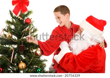 Santa lifts a little boy up to get a candy cane from the top of the Christmas tree.  White background.